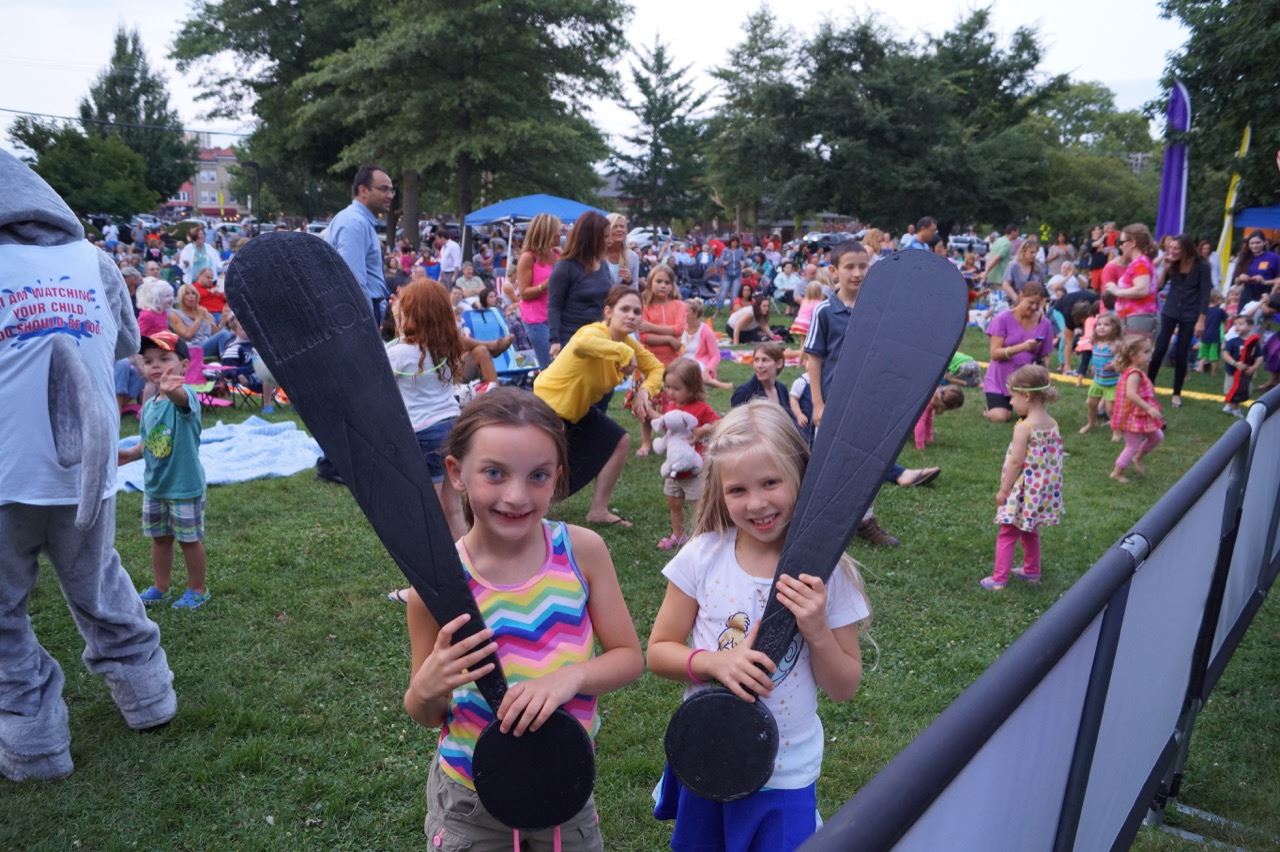 Two little girls hold the Share the Fun exclamation points.